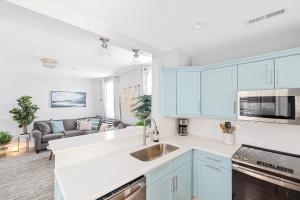 a kitchen with blue cabinets and a living room at Hidden Outdoor Oasis - 1 BLOCK TO KING in Charleston