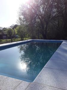 a swimming pool with a reflection in the water at POSADA LAS MARGARITAS in Santa Rosa de Calamuchita