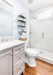 a white bathroom with a toilet and a shower at Hidden Outdoor Oasis - 1 BLOCK TO KING in Charleston
