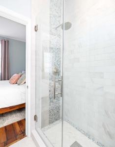 a shower with a glass door in a bedroom at Stunning Secret Courtyard - 1 BLOCK TO KING in Charleston