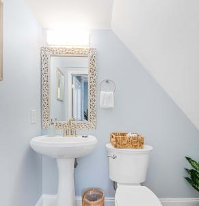 a bathroom with a sink and a toilet and a mirror at Stunning Secret Courtyard - 1 BLOCK TO KING in Charleston