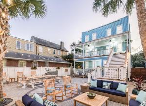 a patio with chairs and tables and a blue house at Stunning Secret Courtyard - 1 BLOCK TO KING in Charleston