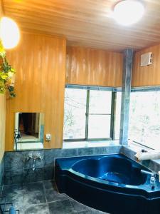 a bathroom with a large blue tub in a room at 木香苑 in Tsumagoi