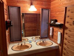 a bathroom with two sinks and a mirror at 木香苑 in Tsumagoi