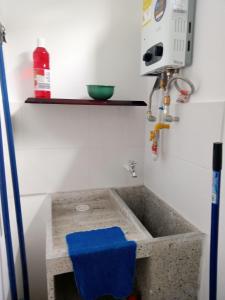 Aparta estudio NUEVO- zona centrica de Bucaramanga في بوكارامانغا: مغسلة الحمام فيها صندوق ازرق