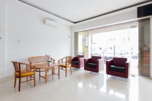 sala de estar con mesa, sillas y ventana en RedDoorz Plus near Living Plaza Jababeka, en Bekasi