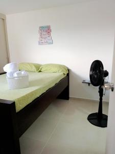 1 dormitorio con 1 cama y ventilador al lado en Aparta estudio NUEVO- zona centrica de Bucaramanga, en Bucaramanga