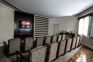 uma fila de cadeiras num quarto com uma televisão em Grande Hotel Glória em Águas de Lindoia