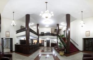 a lobby with a staircase and a chandelier at Grande Hotel Glória in Águas de Lindoia