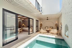 ein Haus mit einem Pool und einem Wohnzimmer in der Unterkunft C4 Estate, Mediterranean-style home in Canggu, 6-min drive to beach in Canggu
