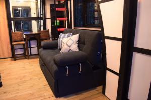 麥德林的住宿－Chalet Tanat，一张黑色沙发,配有两个枕头,位于房间里