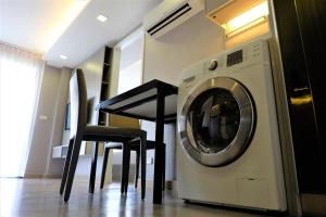a washing machine sitting next to a table and chairs at 18 Residence in Bangkok
