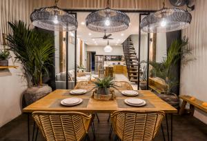 ein Esszimmer mit einem Holztisch und Stühlen in der Unterkunft Tropical Comfort - Private Pool Modern Townhouse in Canggu