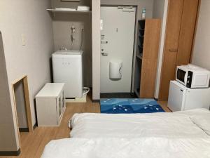 um quarto com uma cama e um micro-ondas no chão em Sky Tree INN (晴樹宿）stay ASAKUSA em Tóquio