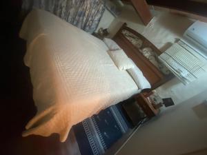 a bed with a white pillow and a book at Country village San Bernardino in San Bernardino