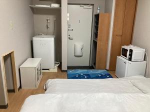 um quarto com uma cama e um micro-ondas em Sky Tree INN (晴樹宿）stay ASAKUSA em Tóquio