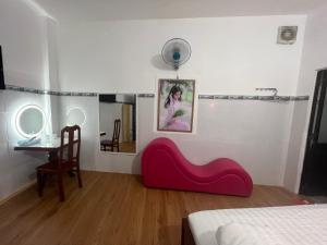 een kamer met een rode stoel en een spiegel bij Mai Phương Thúy Motel in Bien Hoa