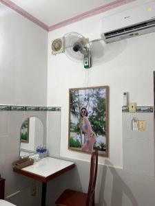 een badkamer met een tafel en een foto van een vrouw bij Mai Phương Thúy Motel in Bien Hoa
