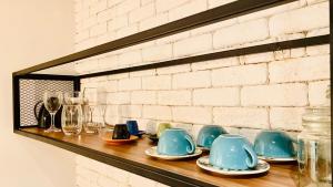 a shelf with blue cups and plates on it at Loft lindo e aconchegante no centro de Teresópolis in Teresópolis