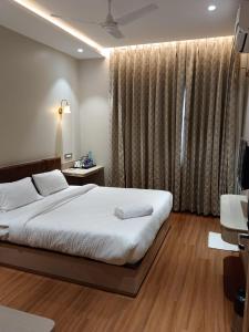a bedroom with a bed and a large window at Buddha Stays in Varanasi