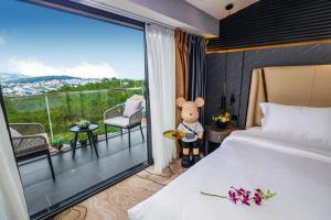 a hotel room with a bed and a view of a balcony at New Century Dalat Hotel in Da Lat