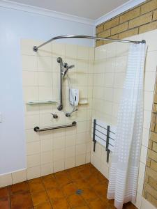 a bathroom with a shower with a shower curtain at Mundubbera Motel in Mundubbera