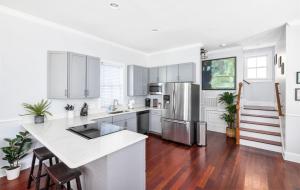 a kitchen with white cabinets and a stainless steel refrigerator at Private Rooftop & Parking - 3 Blocks to King St in Charleston