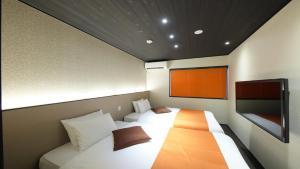 een kleine kamer met 2 bedden en een flatscreen-tv bij Kyoto Ayanishiki Shimabara-Omon Residence【京都 Ayanishiki 島原大門邸】 in Kyoto