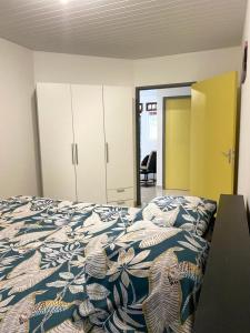 - une chambre dotée d'un lit avec une couverture bleue et blanche dans l'établissement ST-Laurent Haut de Balate Confort, à Saint-Laurent du Maroni