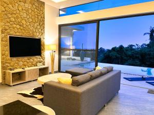 a living room with a couch and a television at VILLA CLARISSE - SEAVIEW - 4 Bedrooms in Koh Samui 