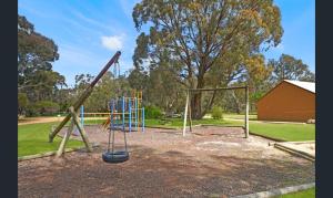 a park with a playground with a swing at Pomonal Cottages Grampians in Halls Gap