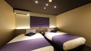 twee bedden naast elkaar in een kamer bij Kyoto Ayanishiki Shimabara-Omon Residence【京都 Ayanishiki 島原大門邸】 in Kyoto