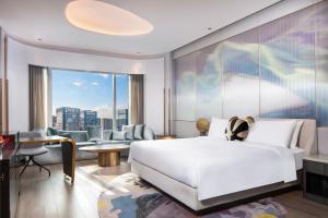 a bedroom with a white bed and a large window at W Chengdu in Chengdu