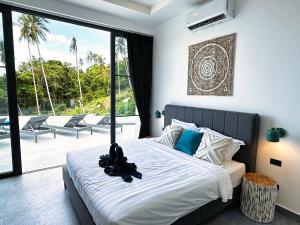 a bedroom with a bed and a balcony with chairs at VILLA CLARISSE - SEAVIEW - 4 Bedrooms in Koh Samui 