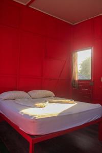 een rode slaapkamer met een bed met een rode muur bij Rocking J's in Puerto Viejo