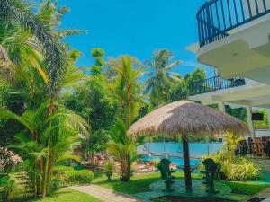 uma vista para um resort com uma piscina e um guarda-sol de palha em Yala River Front Hotel & Restaurant em Tissamaharama