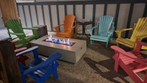 a group of colorful chairs sitting around a fire pit at Adventure Inn - Glenwood Springs in Glenwood Springs