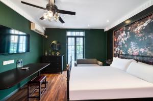 1 dormitorio con cama blanca y pared verde en Men Tang Hotel, en Shanghái