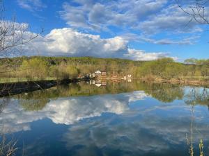 een rivier met een reflectie van wolken in het water bij Dorul Pescarului in Curtea de Argeş