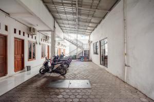 una fila di motociclette parcheggiate in un corridoio di un edificio di RedDoorz Syariah near Jatisampurna Hospital a Bekasi