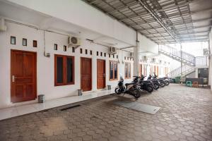 eine Gruppe von Motorrädern, die in einem Gebäude geparkt sind in der Unterkunft RedDoorz Syariah near Jatisampurna Hospital in Bekasi