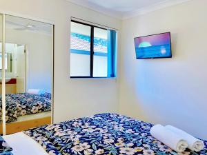 a bedroom with two beds and a tv on the wall at Mermaid Beach Park View in Gold Coast