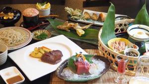 日田市にあるryokan 天龍のテーブルの上に食べ物の皿が置かれたテーブル