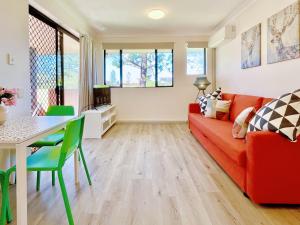 a living room with a red couch and a table at Mermaid Beach Park View in Gold Coast