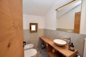 ein Badezimmer mit einem Waschbecken, einem WC und einem Spiegel in der Unterkunft Sonnwarthof in Schlanders