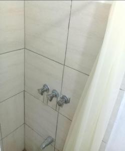 um chuveiro com duas torneiras numa casa de banho em SLEEP-Inn em Scarborough