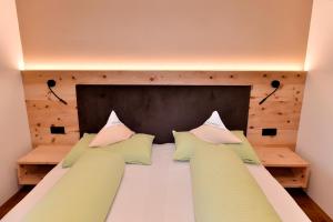 ein Schlafzimmer mit einem großen Bett mit Kissen darauf in der Unterkunft Sonnwarthof in Schlanders