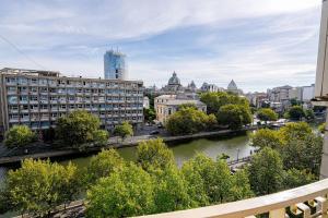 Blick auf eine Stadt mit Fluss und Gebäuden in der Unterkunft Old City Center River View-4BR-Parliament-Metro-Park in Bukarest