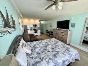 a bedroom with a bed and a living room at Pirates Cove 4th Floor Balcony Remodeled Condo in Daytona Beach