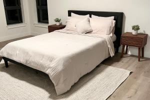 1 dormitorio con 1 cama grande con sábanas y almohadas blancas en Modern 2 Bed Furnished Apartment in Quincy, en Quincy